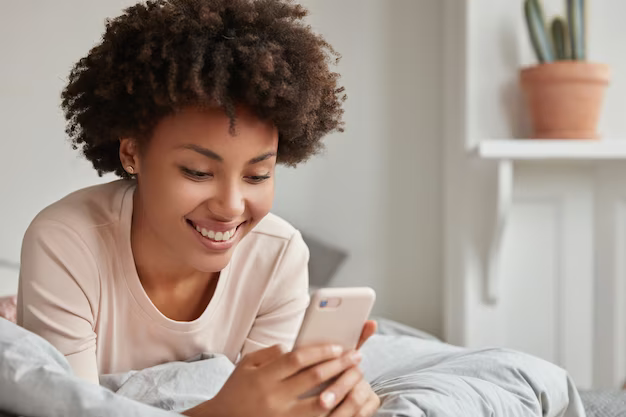 A woman wearing a phone handset smiling.